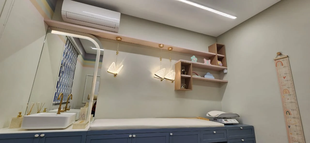 Mesa de exames com régua de crescimento e decoração de borboleta